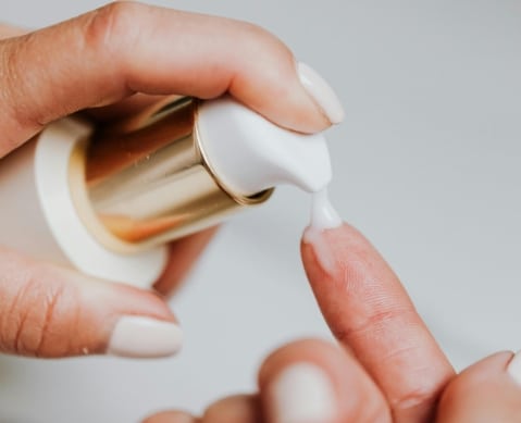 Personne qui utilise un tube de crème